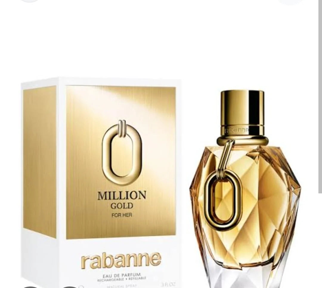 A bottle of Rabanne Million Gold For Her eau de parfum next to its white and gold packaging box, featuring a faceted gold glass bottle with a gold cap and a gold O-shaped ring detail.