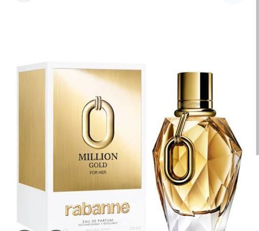A bottle of Rabanne Million Gold For Her eau de parfum next to its white and gold packaging box, featuring a faceted gold glass bottle with a gold cap and a gold O-shaped ring detail.