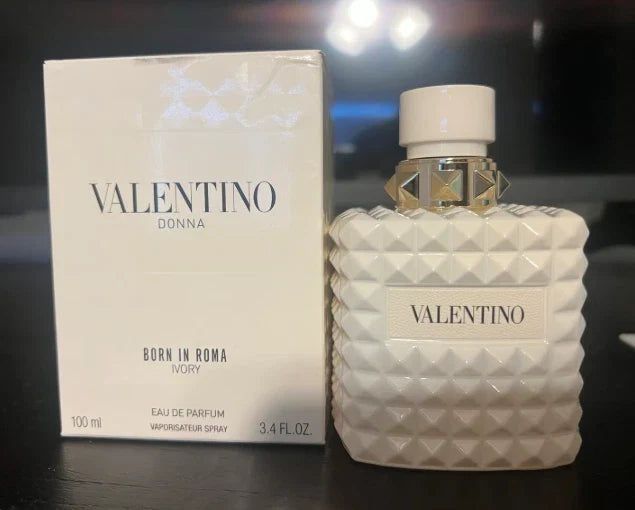 Valentino perfume bottle and packaging on a dark surface